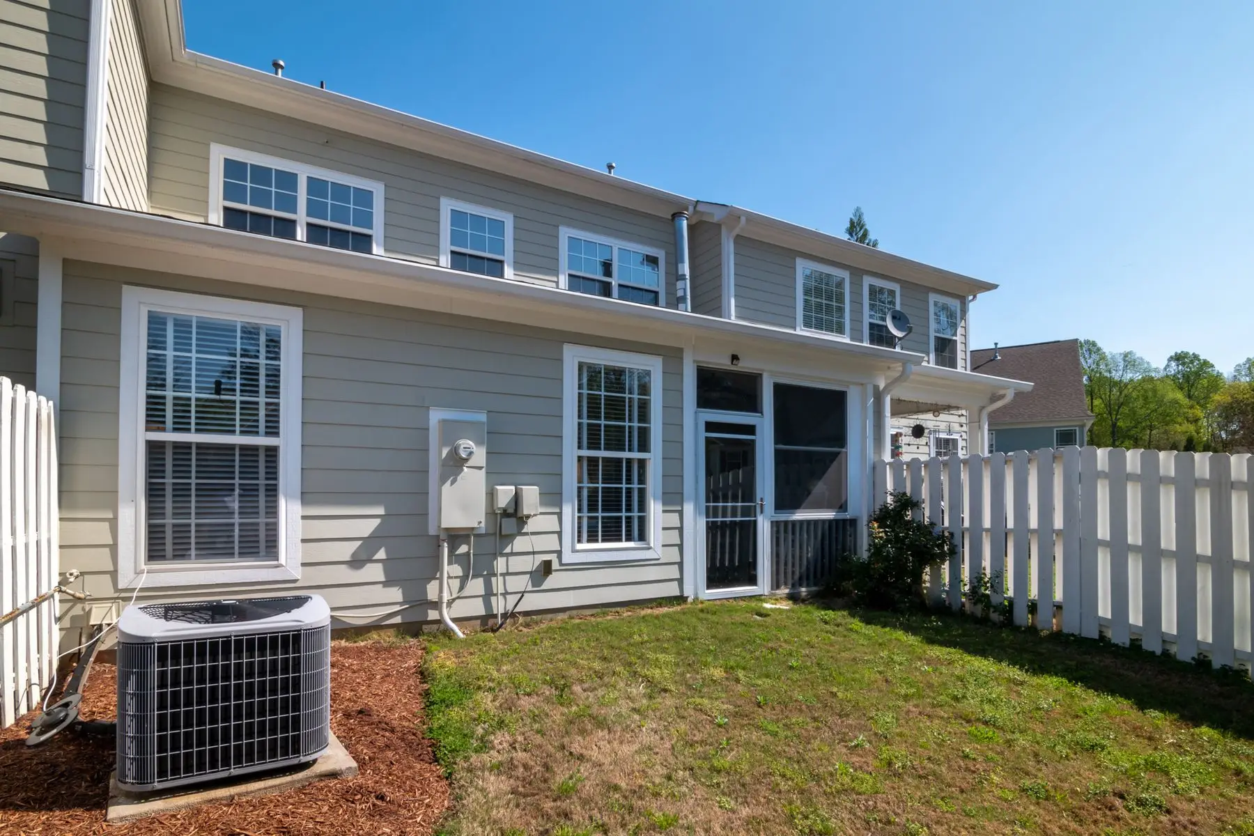 An outdoor condenser unit beside a house