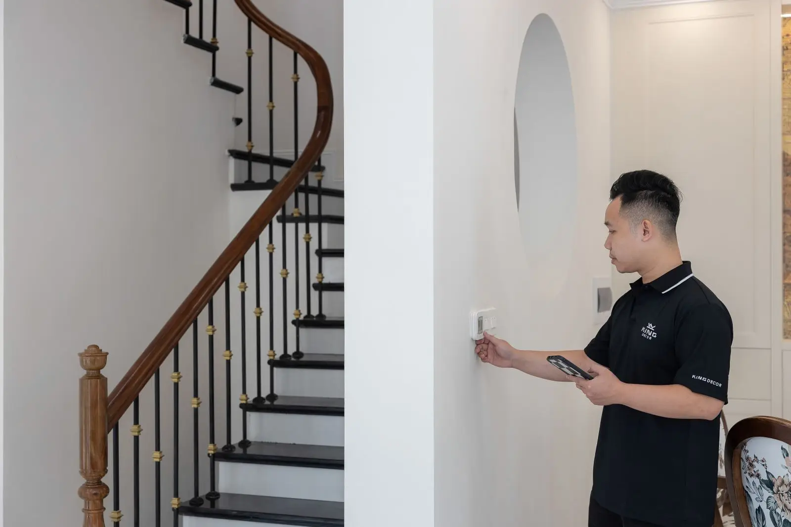 A hand adjusting a wall thermostat